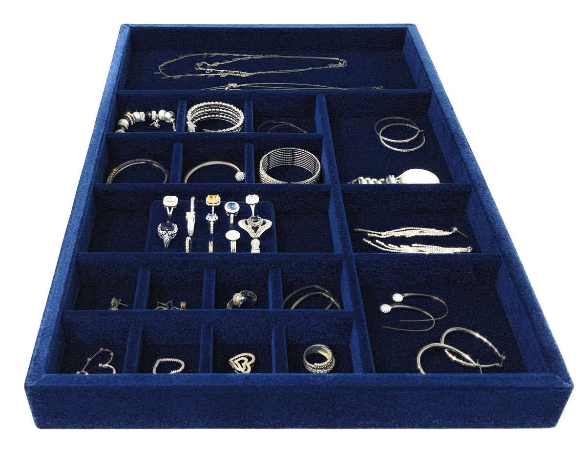 Navy blue velvet custom jewelry drawer insert filled with rings, bracelets, necklaces and earrings